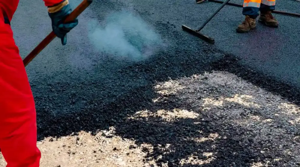 Surfacing crew placing and finishing hot asphalt